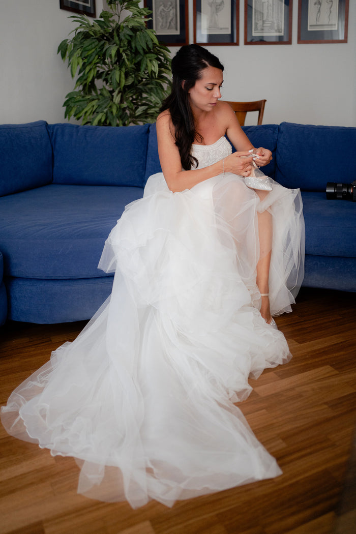 Sposa che allaccia le sue scarpe su misura