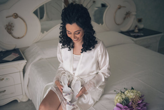 Sposa con in mano le sue scarpe da sposa